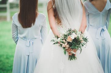 The bride and bridesmaids are showing beautiful flowers on their hands