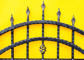 wrought iron fence gate on yellow background