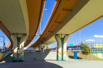 Highway, overpasses and colored concrete columns. Sound absorbing screens are metal frames filled...