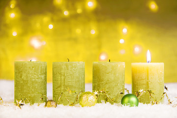 1. advent grüne adventskerzen im schnee