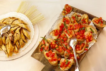 Zelfklevend Fotobehang Piatto con antipasti finger food a crostino e pomodoro e varie sopra un piatto in un tavolo © alex.pin