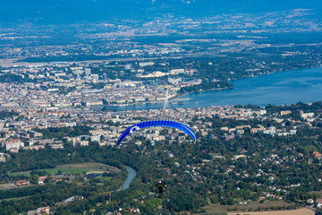 Paraglider in front of an aerial view of Geneva, Switzerland, jet d'eau and lac lemon / geneva lake...