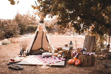 Autumn decorations with wigwam, pumpkins and hay. © morrowlight