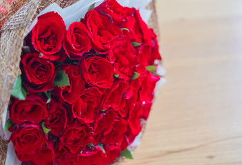 Beautiful red rose bouquet on wood table background
