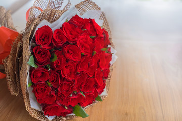 Beautiful red rose bouquet on wood table background