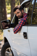 bearded driver in white pickup truck looking at camera © LIGHTFIELD STUDIOS