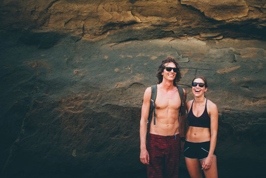 Couple posing against rock face, Canoa, Manabi, Ecuador