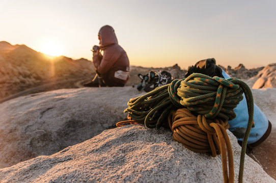 Rock climber on summit at sunset, Joshua Tree, California, USA