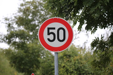 Round speed limit road sign on the road. 50 km per hour.