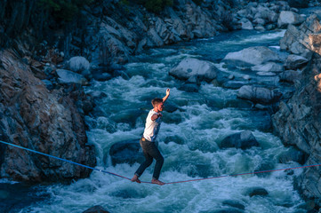 Man highlining above river, Truckee, California, USA