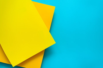 Blue and yellow pastel color papered background. Volume geometric flat lay. Top view. Copy space
