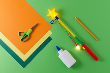 preparation to make diy lantern for sankt martin, traditional german feast, color paper, glue, scissors, lanterns wand with light