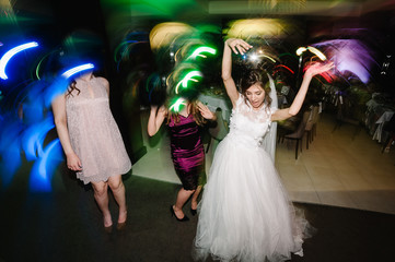 Wedding dance of newlywed and people. bride and groom dancing in restaurant. Wedding couple dancing in smoke and colored lights.