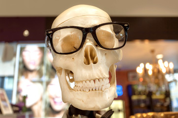 Happy human skull in glasses. Health eyes and body concept. shopping mall. Original design showcase in urban style store