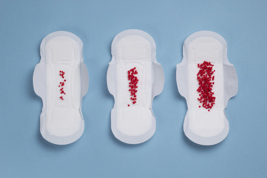 Concept periods. Hygienic pads with red dots on a blue background. Profusion of menstrual.