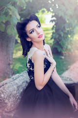 Naklejka premium Sexy dark hair woman looking up and pointing her heart with the hand in black tulle dress