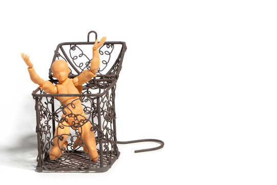 Action figure sitting and hold two hands above the head in open steel cage on isolate background, Concept of tolerance in comfort zone do not dare to change and Fear of change