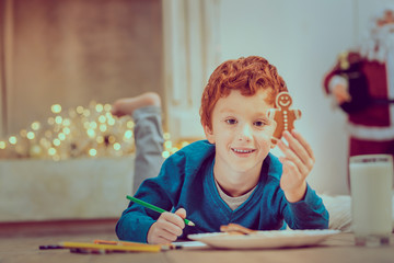 Lets draw it. Joyful boy lying on the floor while posing on camera