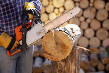 The worker works with a chainsaw. Chainsaw close up. Woodcutter saws tree with chainsaw on sawmill....