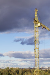 Yellow tower crane against the blue sky.