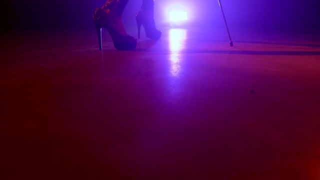 Cellist with electronic cello performs on stage.