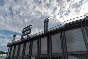 Stadium floodlights against cloudy sky
