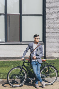 Handsome Confident Asian Man With Laptop Standing At Bike