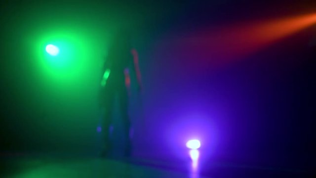 Cellist with electronic cello performs on stage.