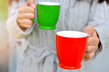 Woman giving cup of hot drink to close person- her boyfriend  family member or friend . Enjoying...