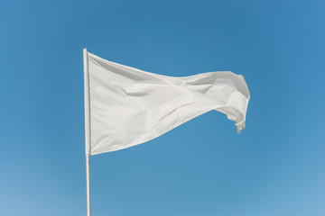 White flag against the blue sky