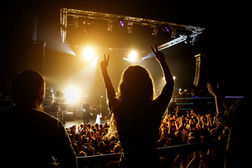 Girl raising her hands and enjoying a great concert.