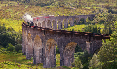 Glenfinnan railway viaduct in Scotland with the Jacobite steam train, located at the northern end...