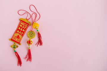 Traditional Vietnamese and Chinese New Year decorations red and golden colors on a pink background, top view.