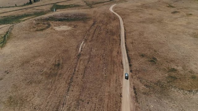 4K aerial view of safari vehicle driving on sand track road in the Altay Mountain. Off road. 4WD. 4 weel drive.