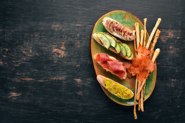 A set of sandwiches with fish, avocados, cucumbers and mushrooms. On a wooden background. Free copy...
