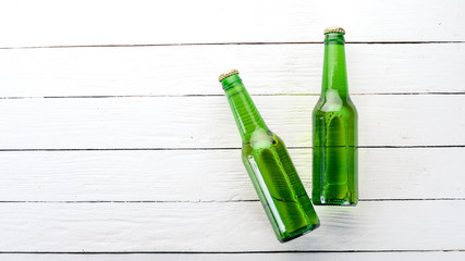 Two bottles of beer On a white wooden background. Free space for text. Top view.