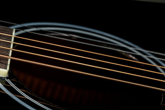 Bronze strings of black acoustic guitar. Music wallpaper