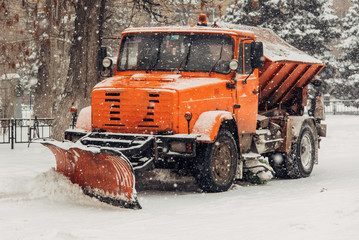 the snowplow stands on the street during the day