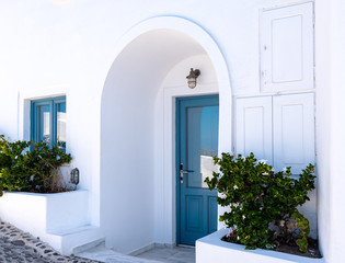 Blue door and blue window in traditional white Greek house at Santorini island, Greece