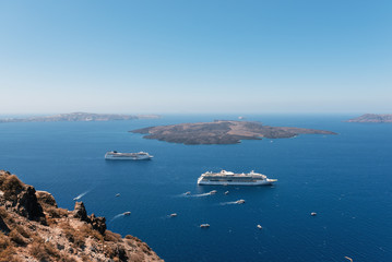 Cruise ships are staying moored in volcanic caldera of Santorini island, Greece