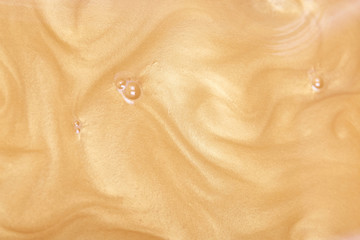 Abstract luxury background, golden paint with waves and currents. sparkling yellow metallic gold....