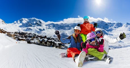 Crédence de cuisine en verre imprimé Sports dhiver Happy family enjoying winter vacations in mountains, Val Thorens, 3 Valleys, France. Playing with snow and sun in high mountains. Winter holidays.