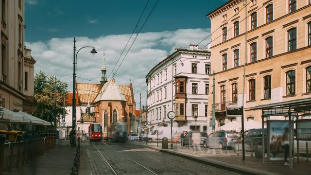 Krakow, Poland. Trams Motion Near Dominican Square. Traffic And Franciscan Monastery and Basilica of St. Francis of Assisi