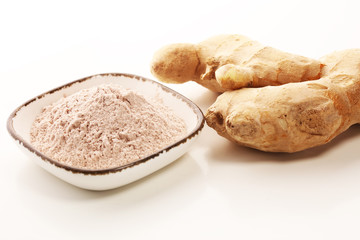 Ginger root and ginger powder in the bowl