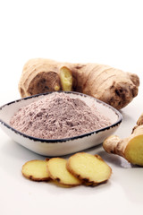 Ginger root and ginger powder in the bowl