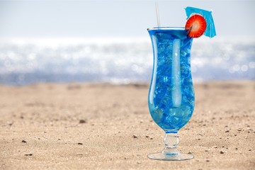 Delicious blue cocktail with ice on blurred