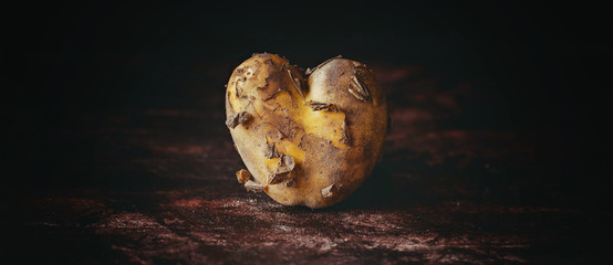Kartoffel in Herzform auf dunklem Hintergrund als Banner