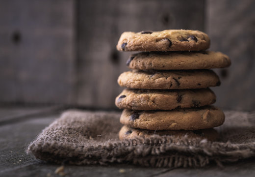 Stacked rounded chocolate cookies on natural old desk.