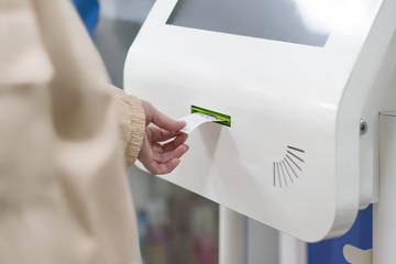 close up customer hand pull a ticket number from dispenser machine to wait in queue in post office f