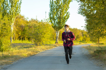 Fototapeta premium young teenager run in the early morning in countryside road beween the green meadows f